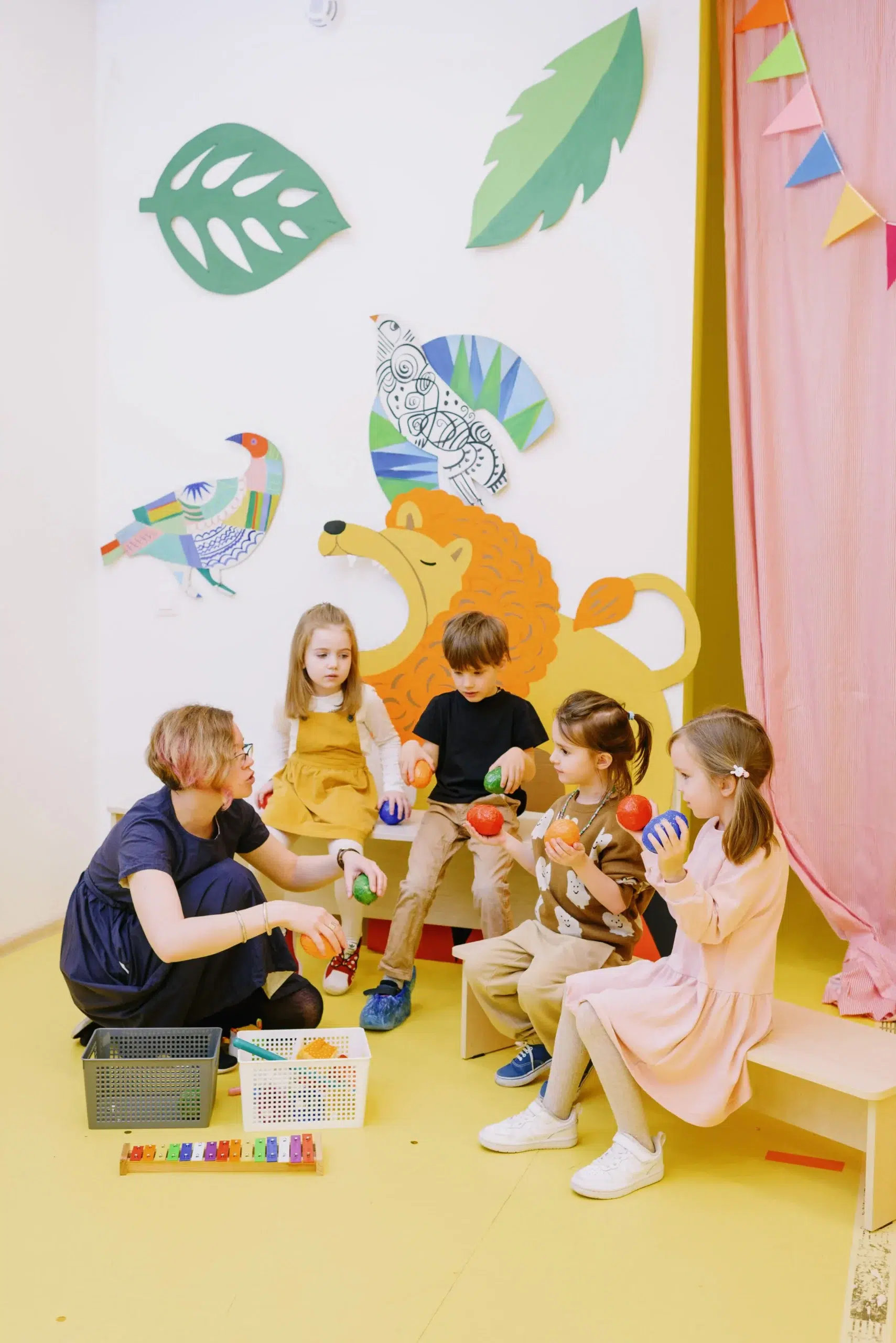 éducatrice de crèche en posture accroupie pour habiller un enfant, illustration des enjeux d'ergonomie en petite enfance
